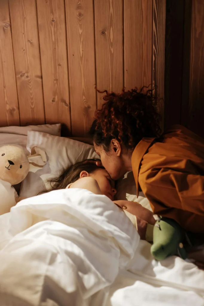 How to Create a Calm Bedtime Routine for Toddlers That Actually Works 11 mother giving goodnight kiss to toddler on bedtime