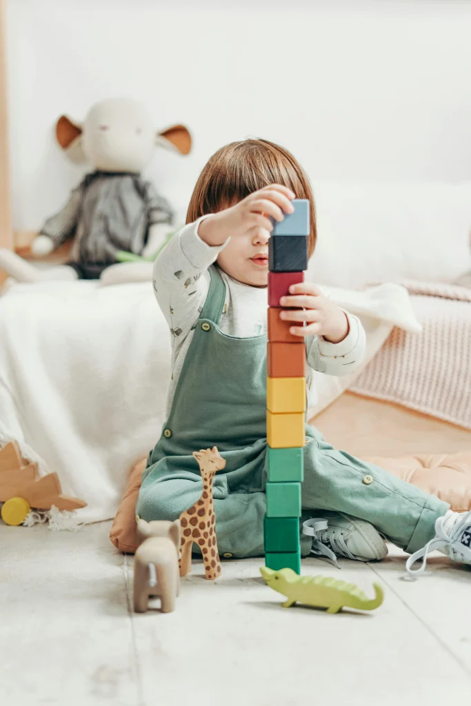 10 Fun Indoor Learning Games for Toddlers That Teach and Entertain 9 toddler making blocks tower